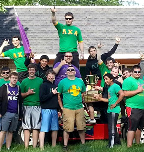 Members ofLambda Chi Alpha pose in their green and yellow colors in front of their fraternity house.