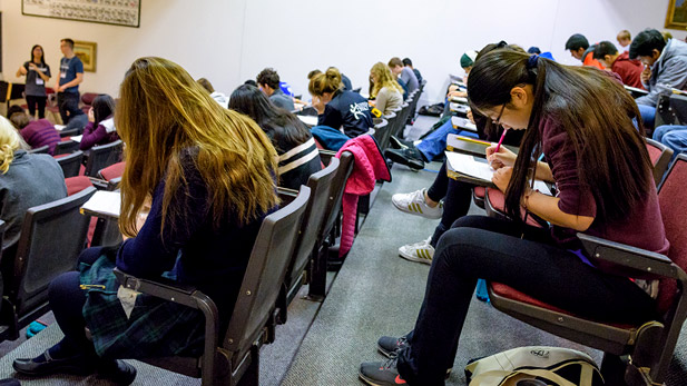 Students seated in a lecture hall while working on mathematics exam