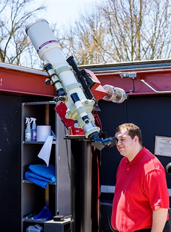 Dylan Linville looks through a telescope at the Oakley Observatory