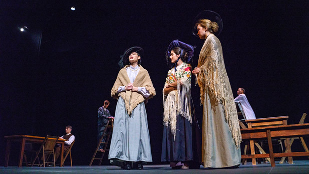 Three female students on stage in period costume