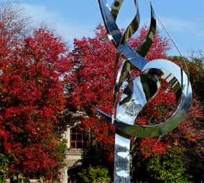 Flame of the Millennium sculpture with fall foliage