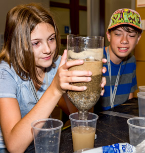 Young students doing hands-on water filtration activity.