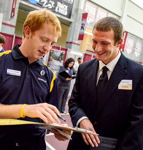 Image shows a Rose-Hulman student asking questions of a business recruiter during a Rose-Hulman Career Fair.