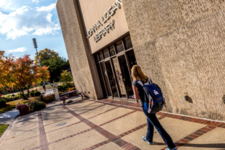 Student walking in front of Logan Library