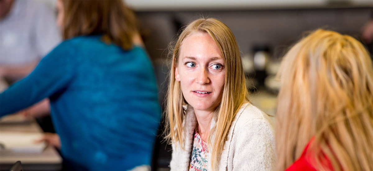 Female professor smiles slightly as she listens to a presentation during a CPSE seminar.