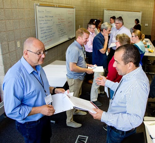 Faculty members standing and participating in one-on-one activities during MACH