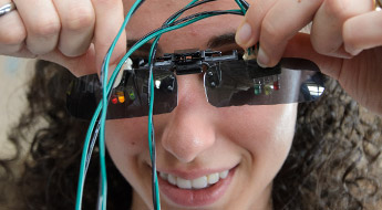 A student uses special glasses to conduct her work in a campus laboratory.