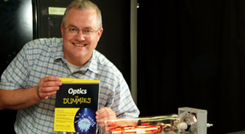 Galen Duree holding his book, Optics for Dummies