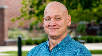 !A smiling Dr. Ed Wheeler standing in the Root Quadrangle at Rose-Hulman