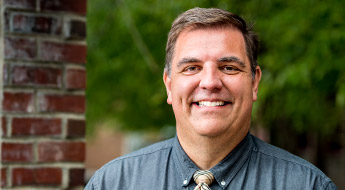 !A smiling Dr. Ross Weatherman standing outdoors on the Rose-Hulman campus