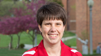 !A smiling Diane Evans standing outdoors on the Rose-Hulman campus