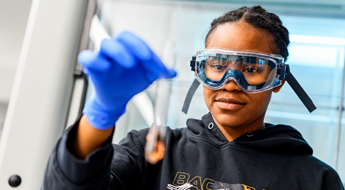 Female student working with test tube in Chemistry Lab. 