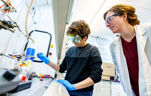 A student and faculty work on an experiment in a chemistry lab.