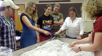 Students gather around the stream table and spray water.