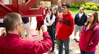 Students listen to speaker outside.