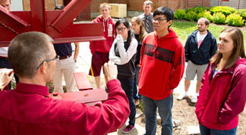 Student listen to professor outside.