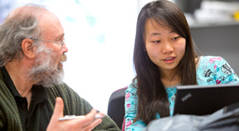 Male professor talks to female student.