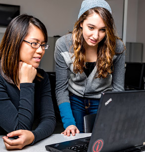 Two members of WOLF-PAC working together at a laptop computer.