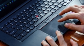 Image of hands using a laptop keyboard.