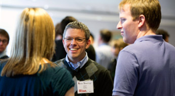 Students standing and talking in a circle at a RISE social event.