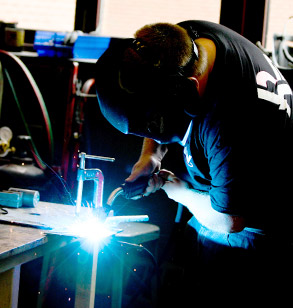 Student welding in the machine shop.