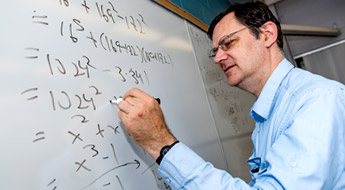 Dr. Rickert writing equations on a white board.