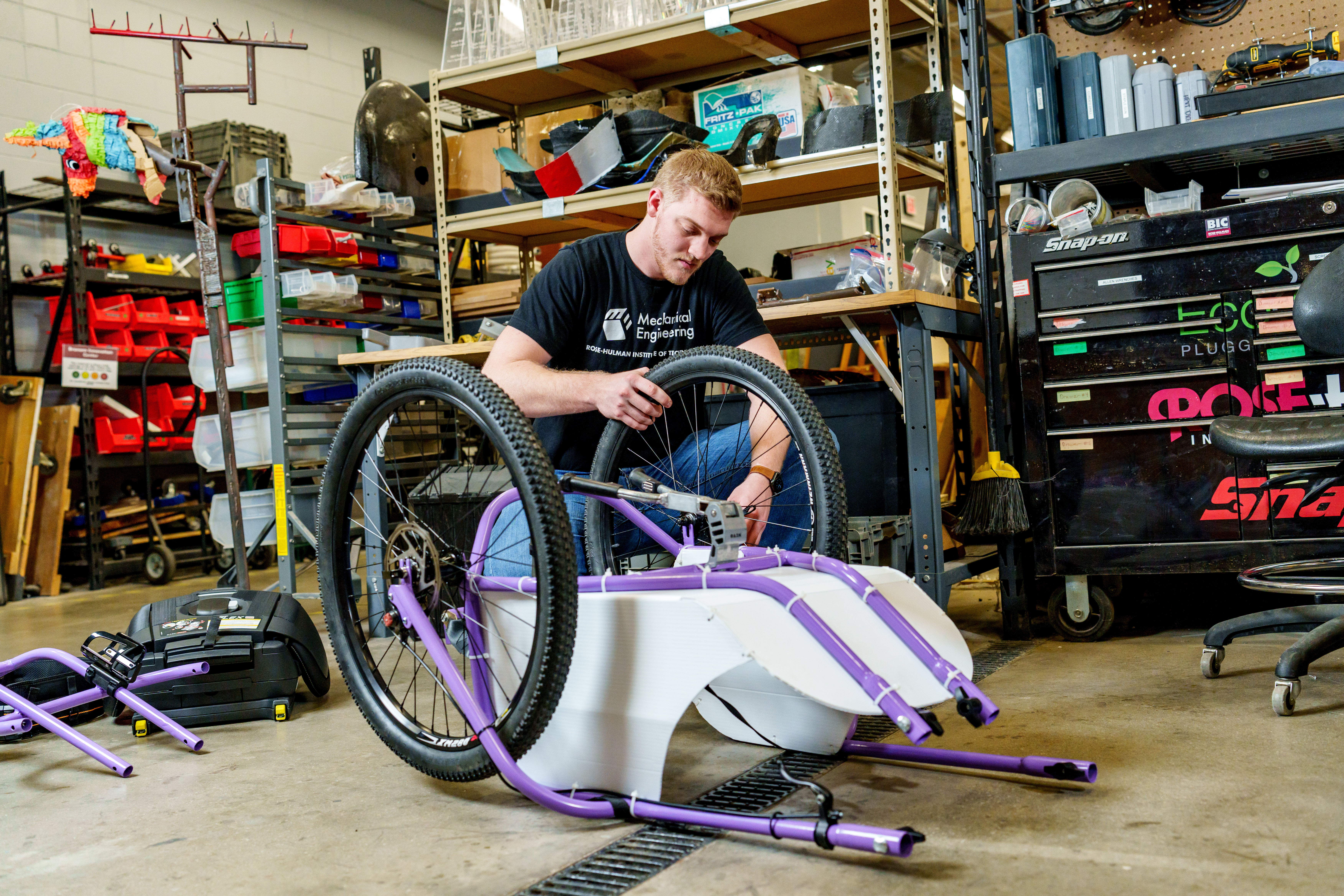 Student works on the wheels of a hiking wagon project.