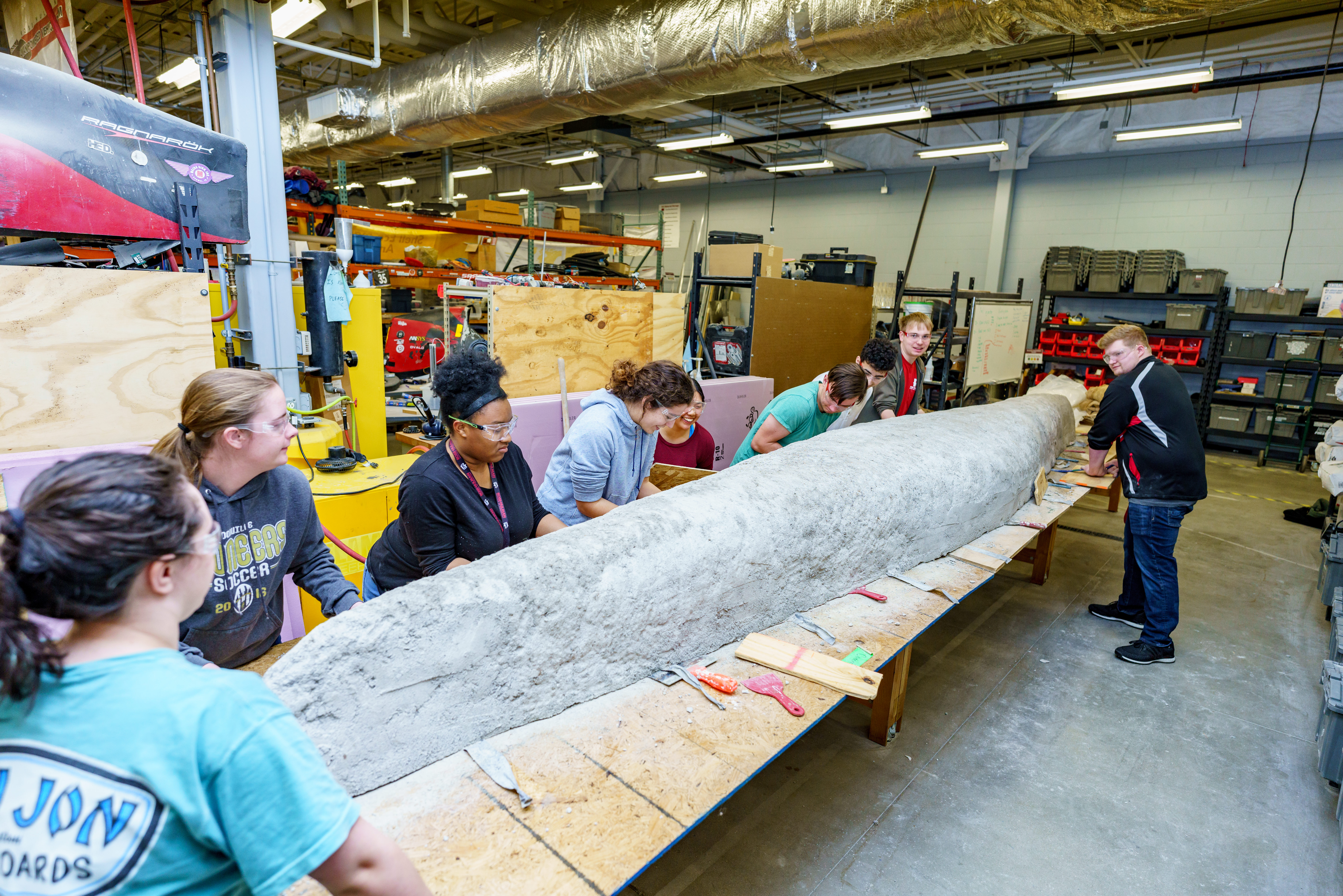 Group of students working on concrete canoe.