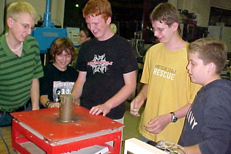 Students create concrete cylinder while learning about civil engineering principles.