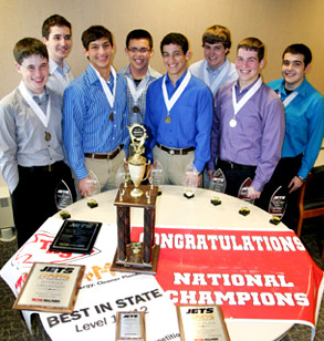 Members of a high school team pose with state and national trophies