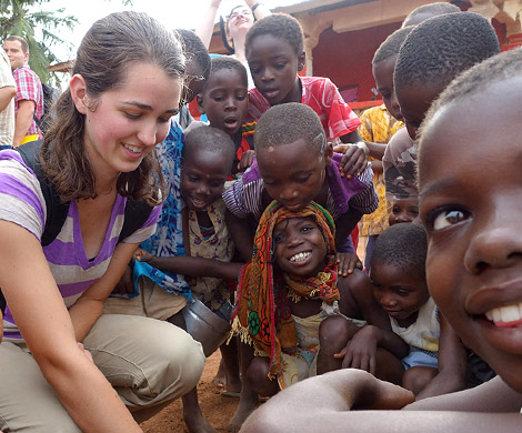 Female Rose-Hulman student with a group of young African children in Ghana.