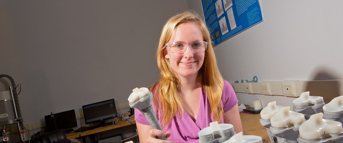 Female student working with artificial knee joints. 