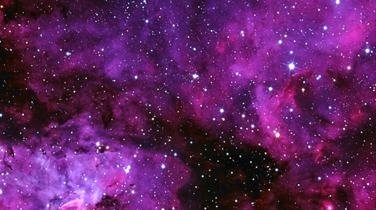An image of a cloudy purple haze known as the Carina Nebula.