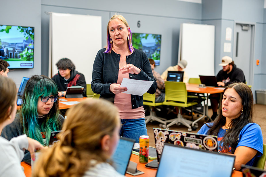 Faculty addresses classroom of students.
