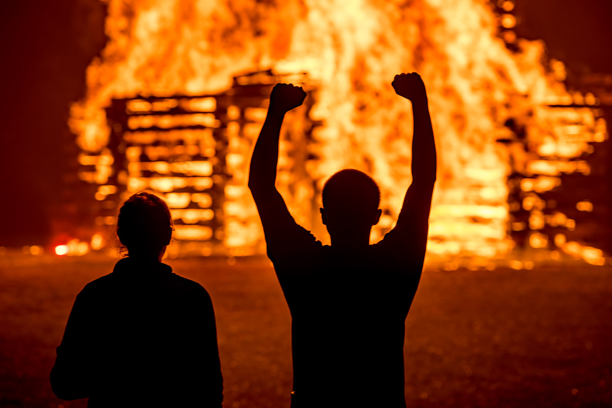 Student silhouettes against the bonfire