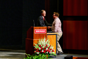 !Image of alumni receiving an award behind a podium.