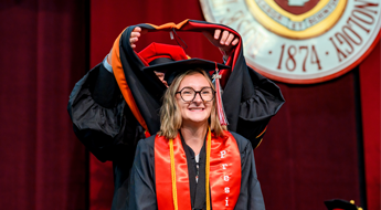 Student graduating and receiving hood. 
