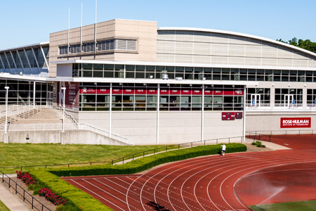 An outside view of the Student Recreation Center under a blue sky with a portion of the running track visible. 