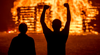 !Students wearing hardhats building the annual bon fire tower using hundreds of railroad ties.