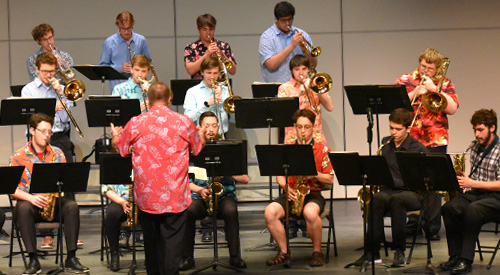 !Students performing on musical instruments on stage