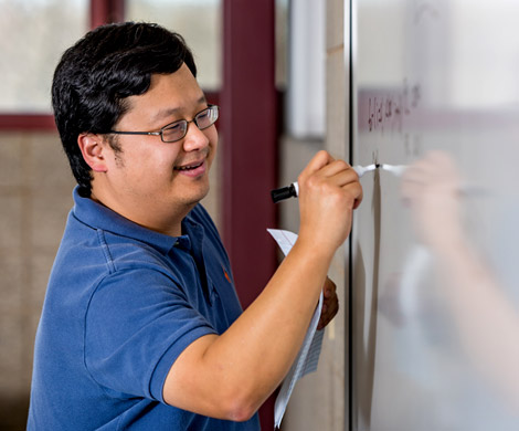 Dr. Daniel Chang writing on white board.