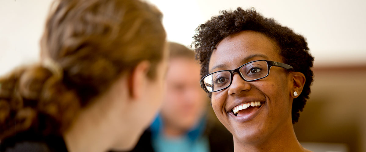 Two female students talking and smiling.