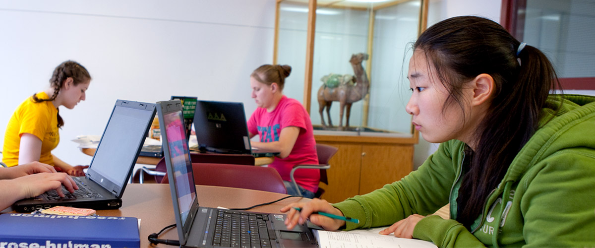 Three female students in the Learning Center working on laptop computers.