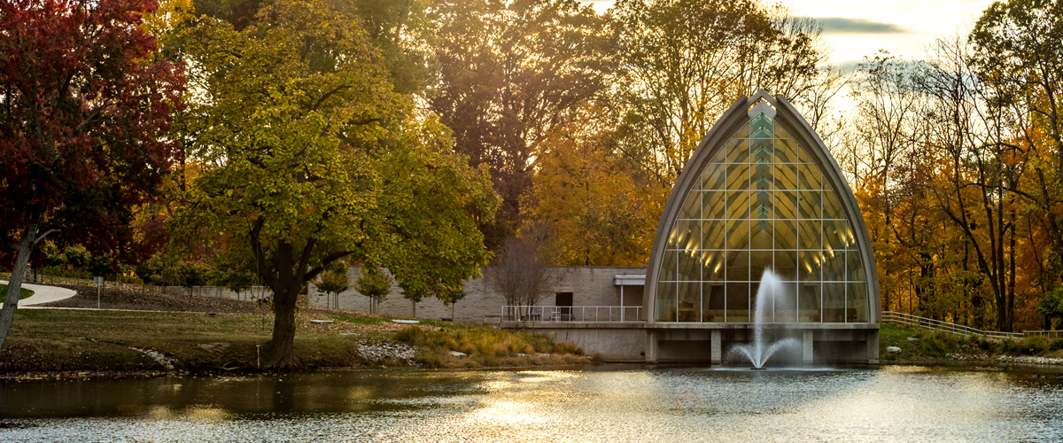 A fall image of White Chapel seen from across Speed Lake with a fountain in the lake spewing water into the air