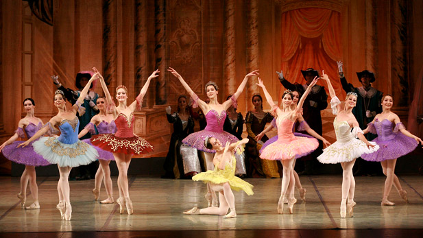 Ballet dancers in colorful costumes dance across a stage