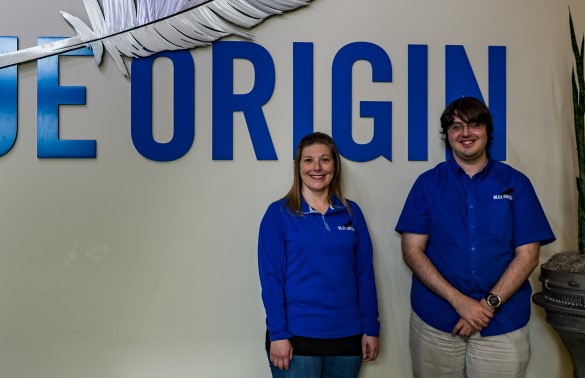 Michelle Costenaro and Ian Malik standing in front of a large Blue Origin sign at company facility.
