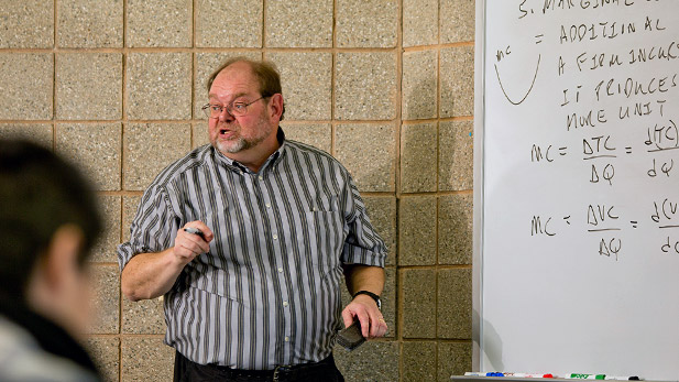 Rose-Hulman Economics Professor Dale Bremmer stands before a whiteboard and gives a classroom lecture.