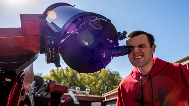 Student looking through a telescope