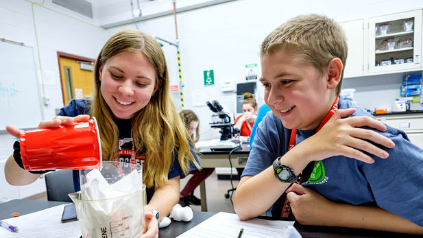 Smiling female and male students work in a lab during Project Select