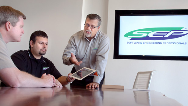 Jeff Gilbert gestures to others in a conference room